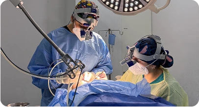 Equipo médico realizando una cirugía capilar con instrumental especializado en quirófano.