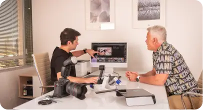 Consulta capilar en Bravo Hair Institute realizada por el Dr. Freddy Bravo, revisando resultados en pantalla con un paciente